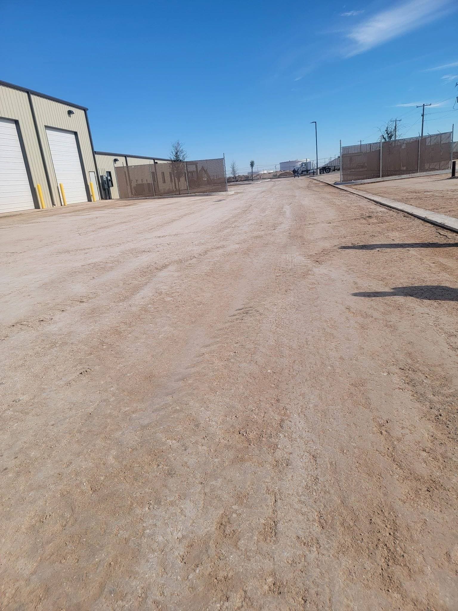 Graded site access road beside a commercial building in West Texas